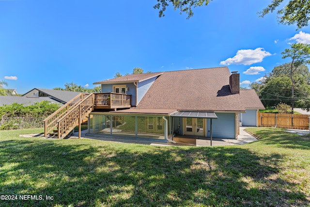 rear view of house featuring a lawn, a wooden deck, and a patio area