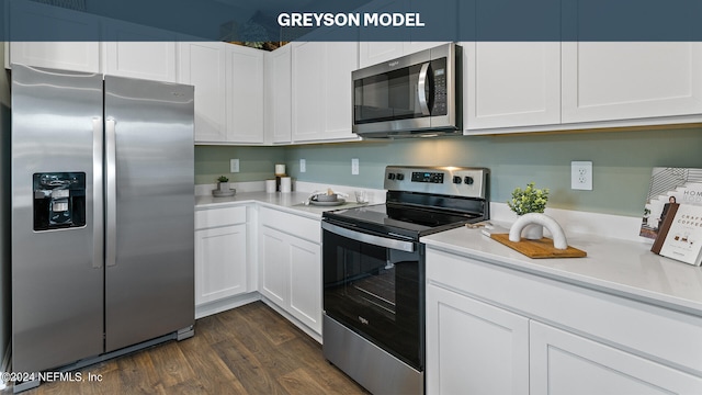 kitchen with appliances with stainless steel finishes, dark wood-type flooring, and white cabinetry