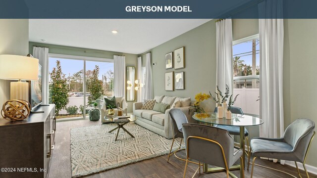 living room featuring a notable chandelier, hardwood / wood-style floors, and a healthy amount of sunlight