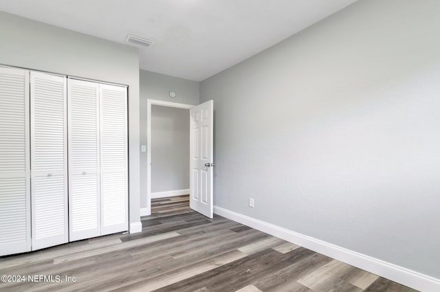 unfurnished bedroom featuring a closet and hardwood / wood-style flooring