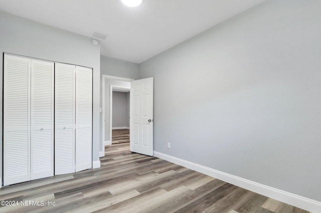 unfurnished bedroom featuring light hardwood / wood-style flooring and a closet