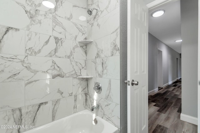 bathroom with wood-type flooring and tiled shower / bath