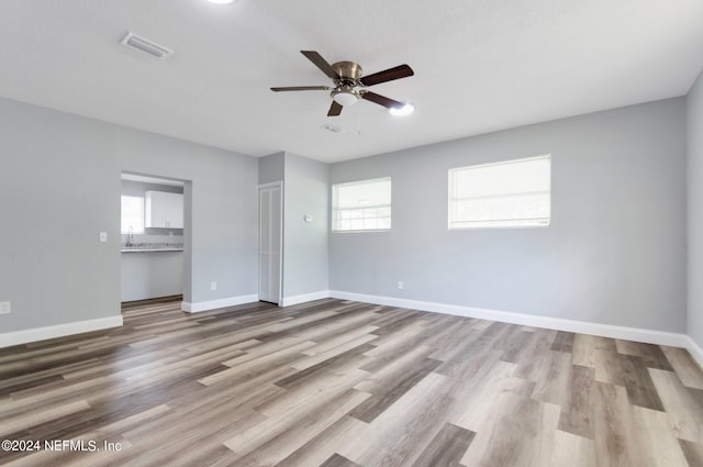 unfurnished bedroom featuring light wood-type flooring, sink, and ceiling fan