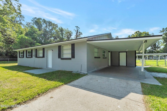 view of front of property featuring a front lawn and a carport