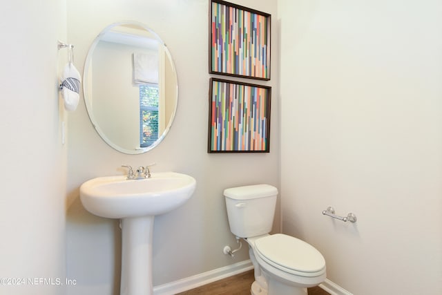 bathroom featuring wood-type flooring, sink, and toilet