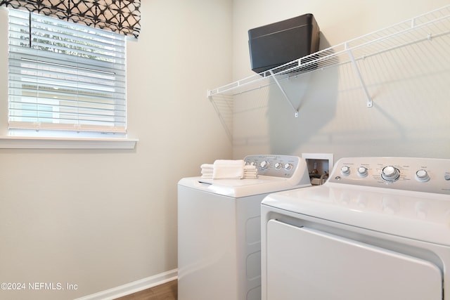 laundry area with hardwood / wood-style floors and washer and dryer