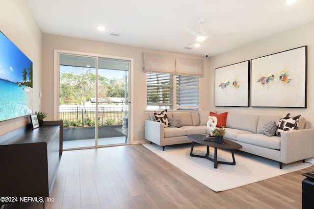 living room with light hardwood / wood-style floors and ceiling fan