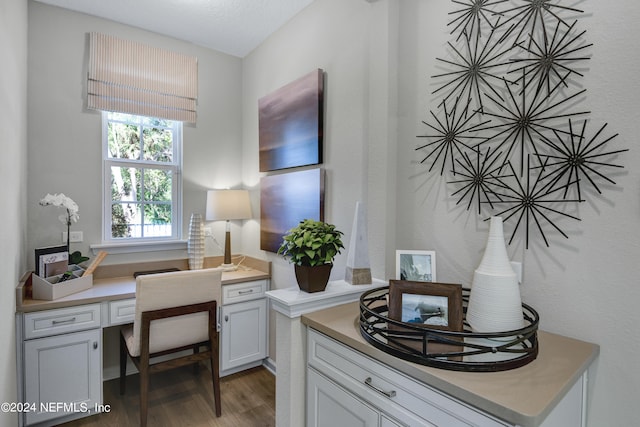 office area with built in desk, a textured ceiling, and dark hardwood / wood-style floors