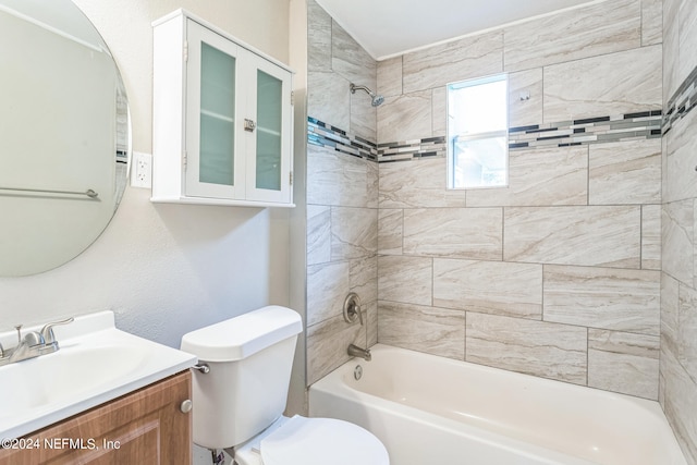 full bathroom with tiled shower / bath, vanity, and toilet