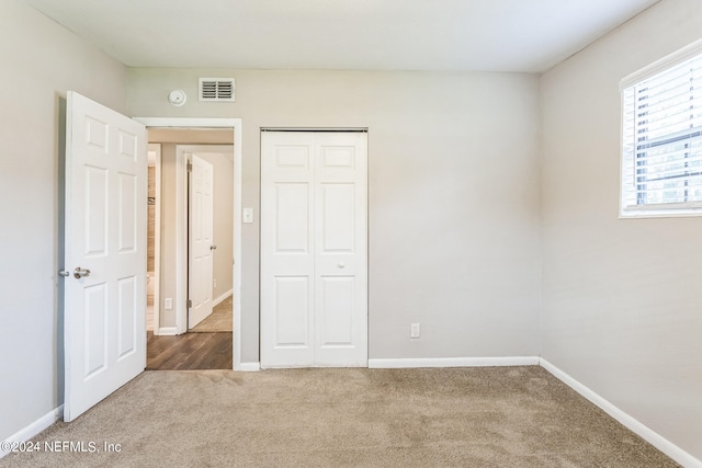 unfurnished bedroom featuring carpet and a closet