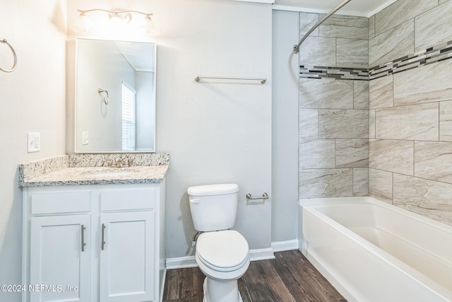 full bathroom with tiled shower / bath, hardwood / wood-style flooring, vanity, and toilet