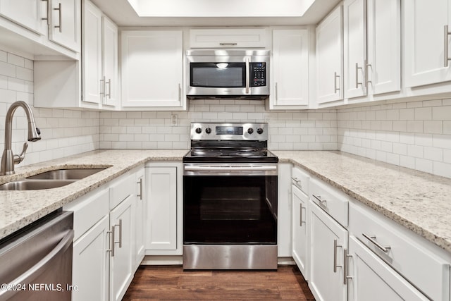 kitchen featuring light stone counters, dark wood-type flooring, sink, white cabinetry, and appliances with stainless steel finishes