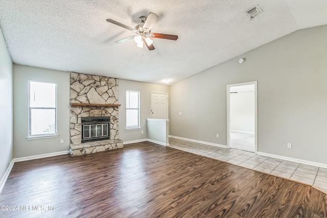 unfurnished living room with a textured ceiling, vaulted ceiling, and hardwood / wood-style flooring