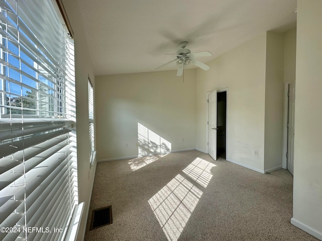 spare room with light carpet, lofted ceiling, and ceiling fan