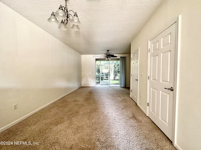 carpeted empty room with a textured ceiling and ceiling fan with notable chandelier