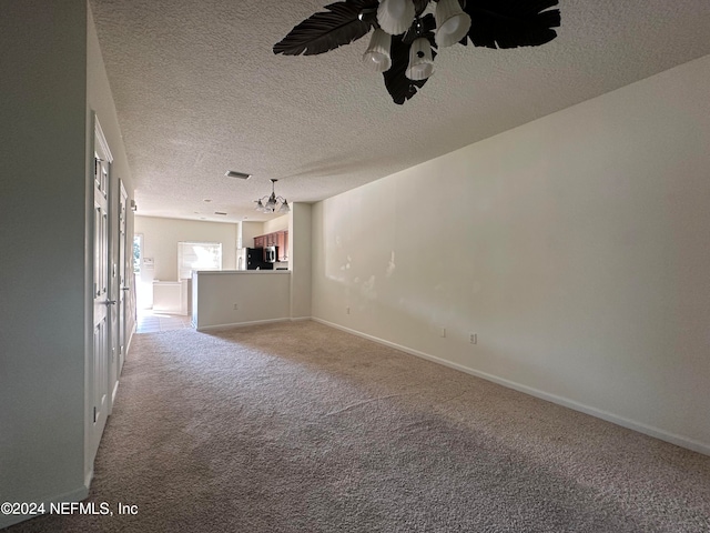 unfurnished living room with a textured ceiling, ceiling fan, and light carpet