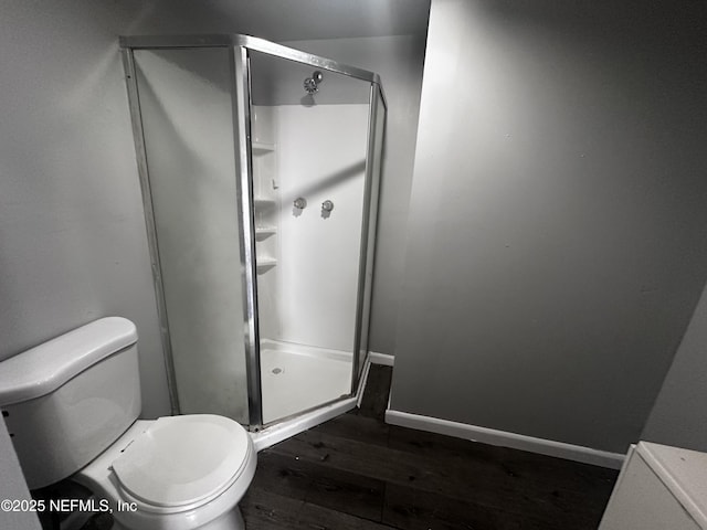 full bath featuring a stall shower, wood finished floors, toilet, and baseboards