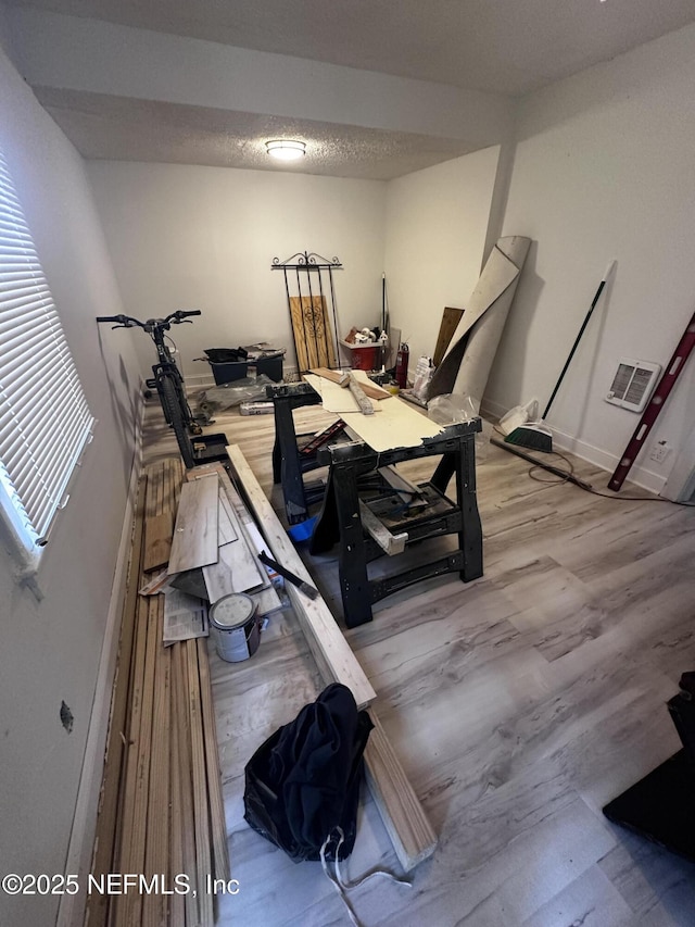 exercise room with visible vents, a textured ceiling, and wood finished floors