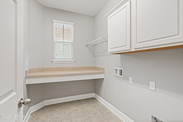 washroom with washer hookup, cabinets, light tile patterned floors, and a textured ceiling