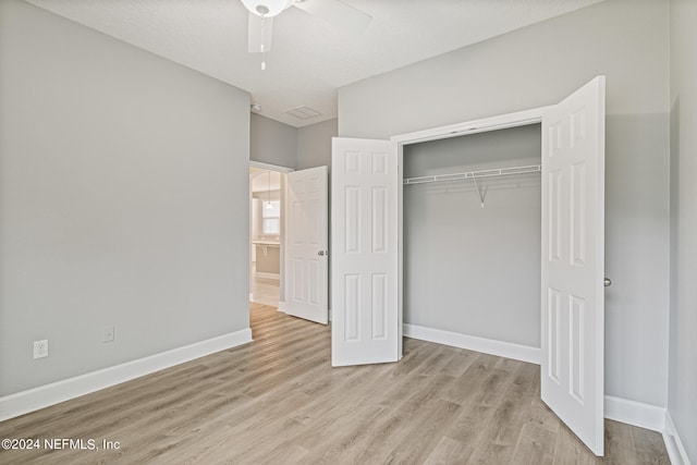 unfurnished bedroom featuring a textured ceiling, light hardwood / wood-style floors, ceiling fan, and a closet