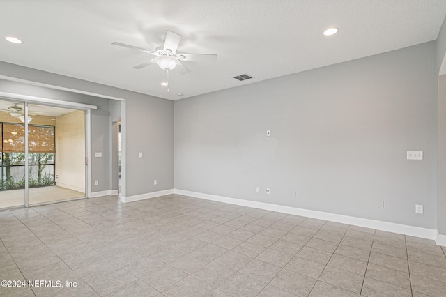 tiled empty room featuring ceiling fan and a textured ceiling