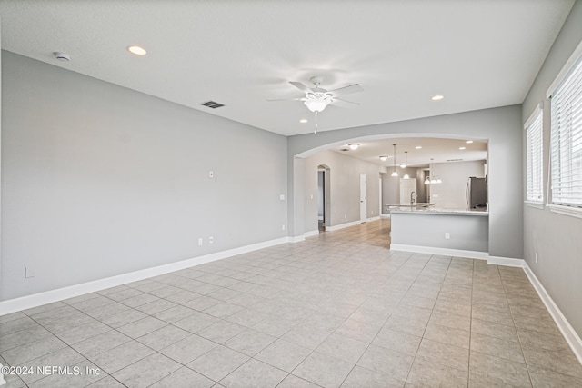 unfurnished living room featuring light tile patterned floors and ceiling fan