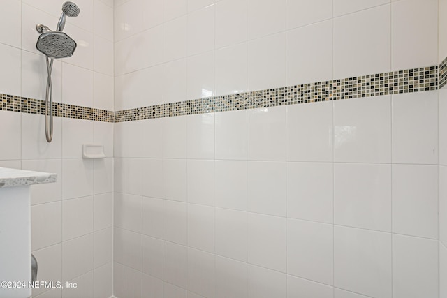 interior details featuring a tile shower