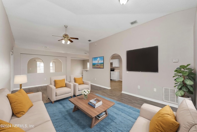 living room with vaulted ceiling, dark hardwood / wood-style floors, and ceiling fan