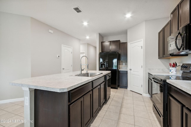 kitchen featuring dark brown cabinets, a kitchen island with sink, black appliances, and sink