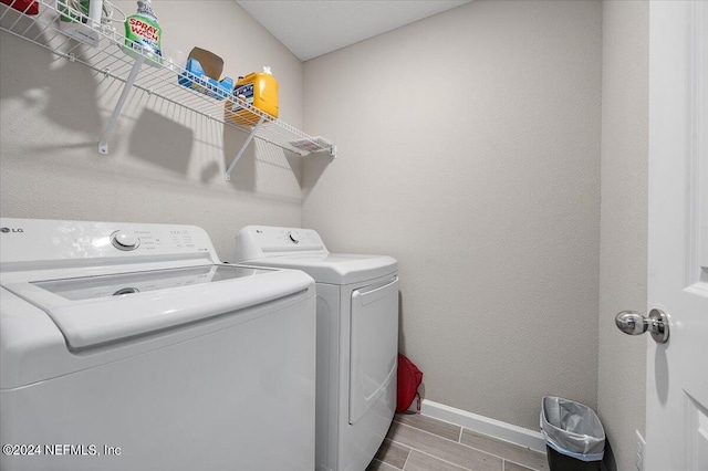 clothes washing area featuring wood-type flooring and separate washer and dryer