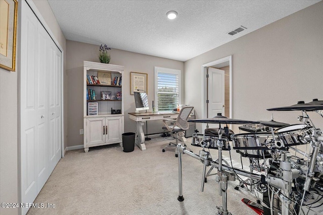 carpeted office with a textured ceiling