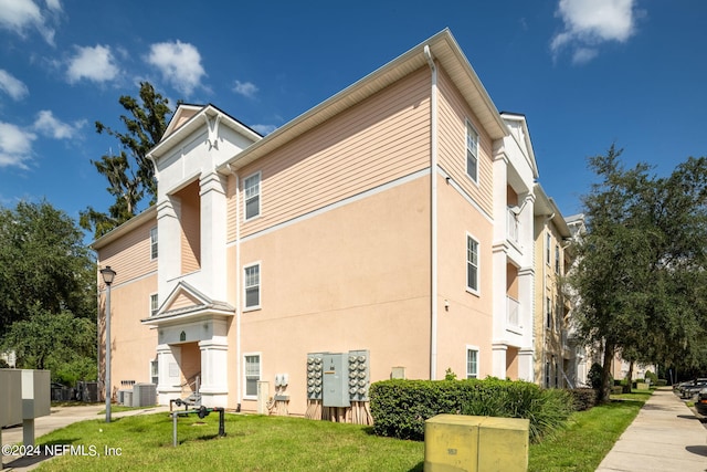 view of side of property with a lawn and central air condition unit