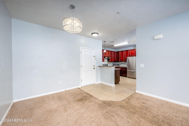 kitchen featuring decorative backsplash, light colored carpet, appliances with stainless steel finishes, and decorative light fixtures