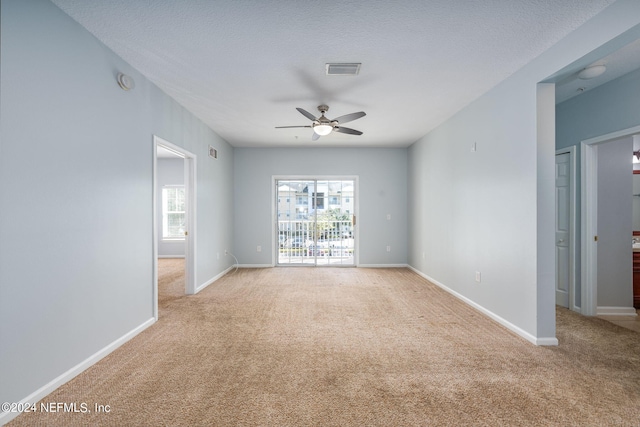 carpeted spare room with ceiling fan and a textured ceiling