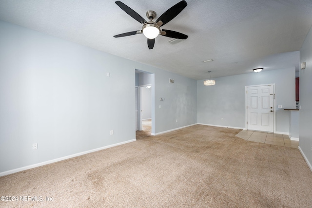 carpeted empty room with ceiling fan and a textured ceiling