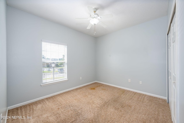 empty room featuring carpet floors and ceiling fan