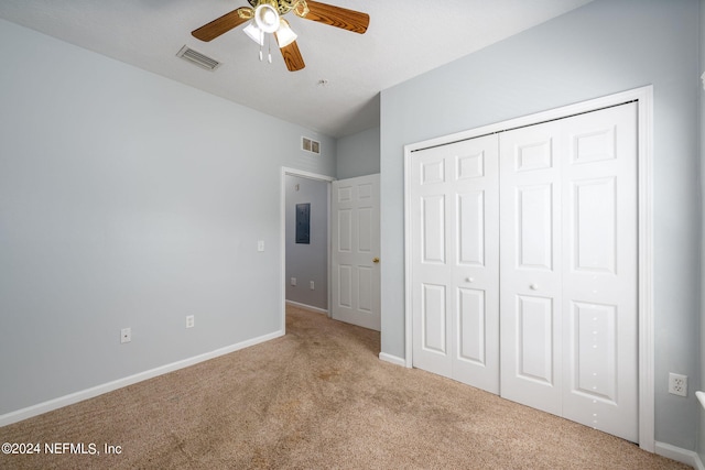 unfurnished bedroom with electric panel, light carpet, ceiling fan, and a closet