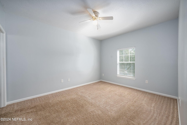 carpeted spare room with ceiling fan and a textured ceiling