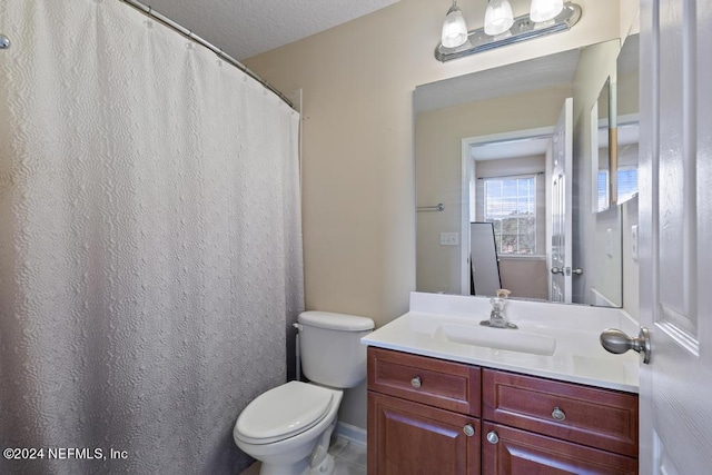 bathroom with vanity, toilet, and a textured ceiling