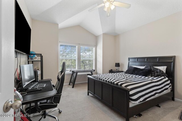 bedroom with ceiling fan, vaulted ceiling, and light colored carpet