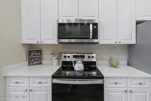 kitchen with stainless steel appliances and white cabinetry