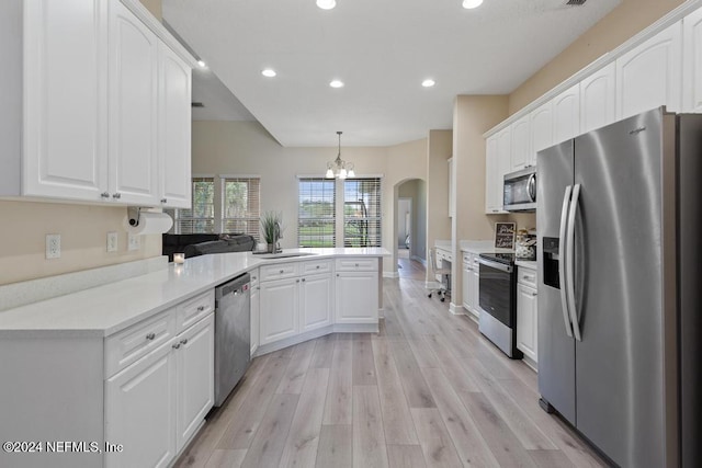 kitchen with light wood-type flooring, decorative light fixtures, stainless steel appliances, kitchen peninsula, and white cabinets