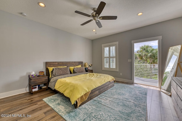 bedroom with ceiling fan, a textured ceiling, hardwood / wood-style floors, and access to exterior