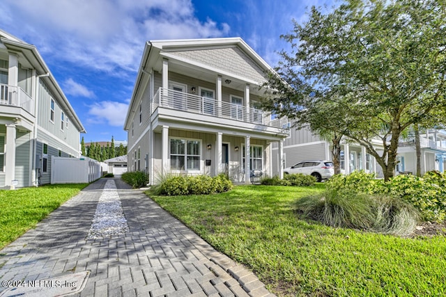 view of front of home featuring a balcony, a front lawn, and a porch