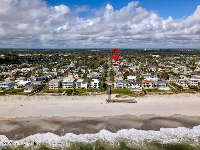 birds eye view of property with a water view and a beach view