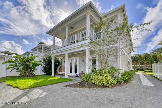 view of front of house featuring a balcony and french doors