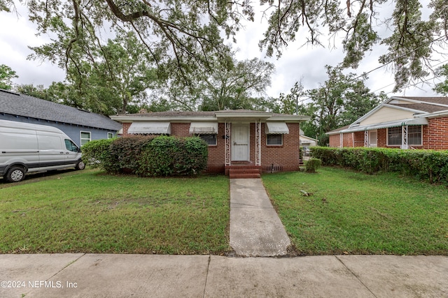 ranch-style home featuring a front lawn