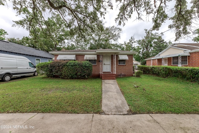 1340 W 11th St, Jacksonville, FL 32209 - view of front of house with a front yard and brick siding