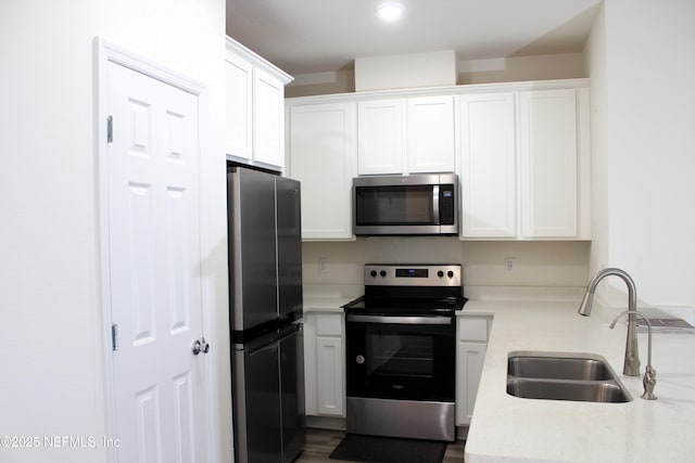 kitchen featuring white cabinets, sink, and appliances with stainless steel finishes