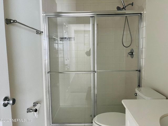 bathroom featuring vanity, toilet, and an enclosed shower